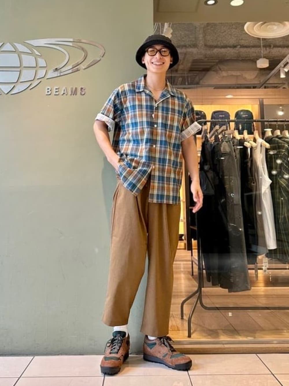 オレンジ系のシャツ/ブラウス、ブラック系のその他パンツ、ブラウン系のスニーカーを着用したメンズの夏コーディネートの2枚目の写真