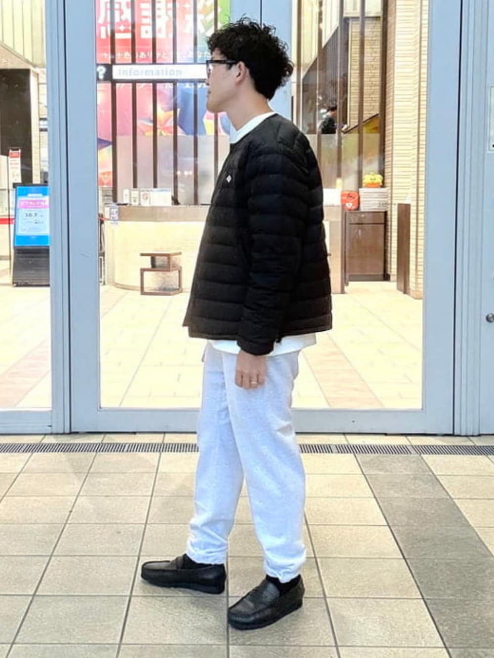 グレー系のスウェットパンツ、ブラック系のダウンジャケット/コート、ホワイト系のTシャツ/カットソーを着用したメンズの秋コーディネートの3枚目の写真