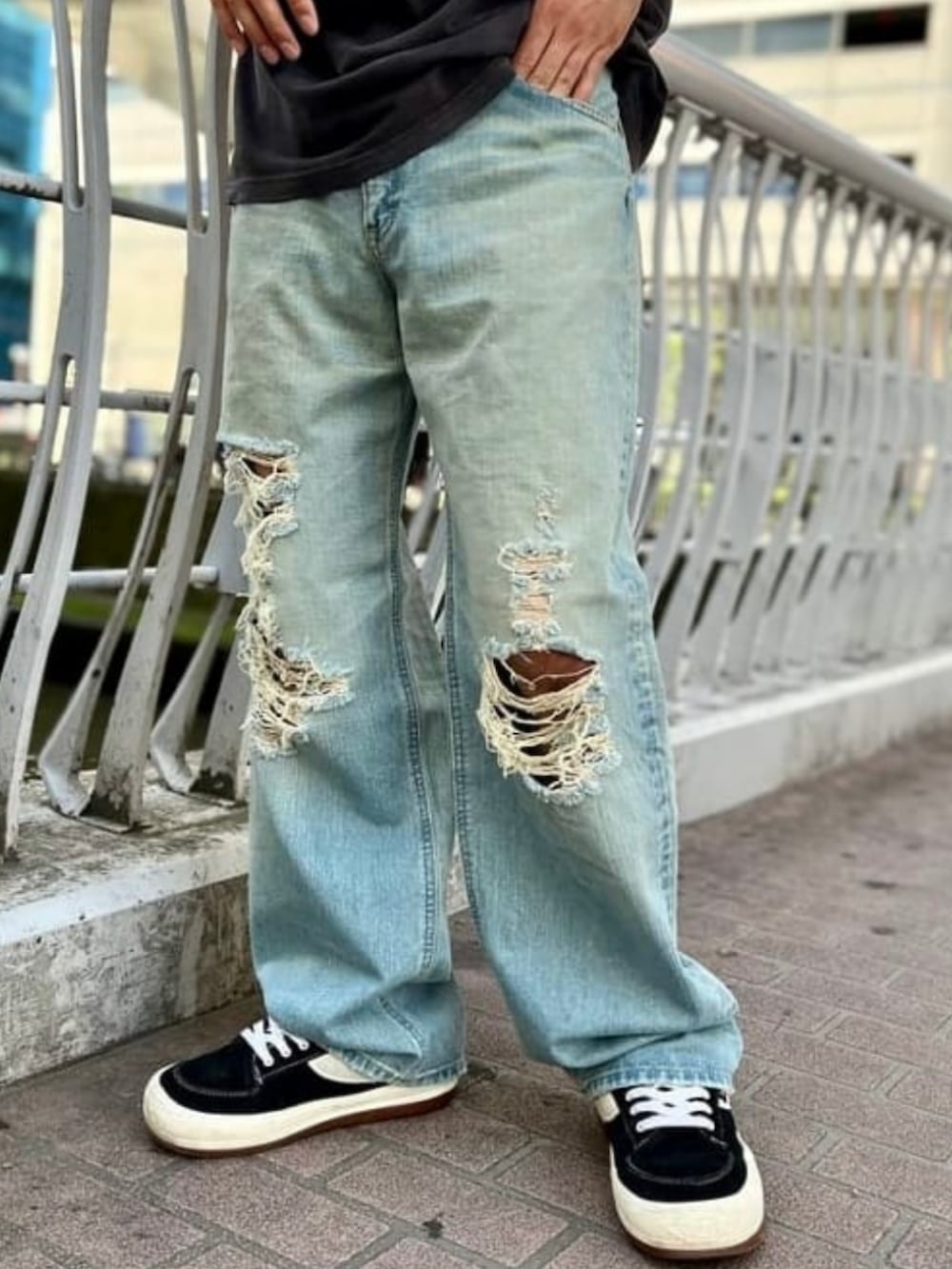 ブルー系のデニムパンツ、ブラック系のTシャツ/カットソー、ブラック系のスニーカーを着用したメンズの春コーディネートの3枚目の写真