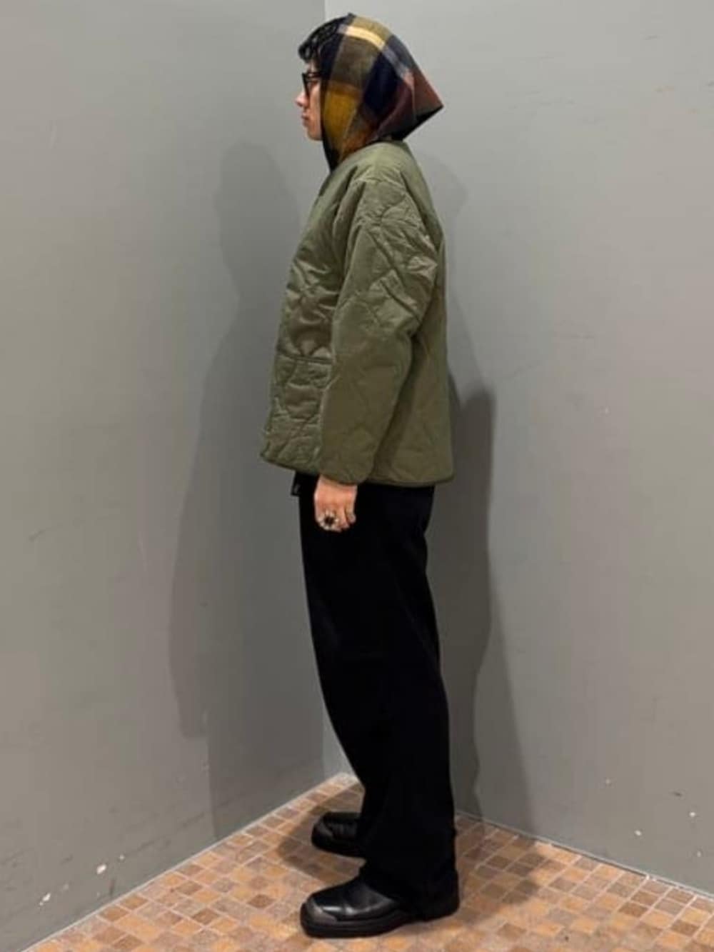 グリーン系のミリタリージャケット、ブラック系のその他パンツ、グレー系のマフラーを着用したメンズの冬コーディネートの2枚目の写真