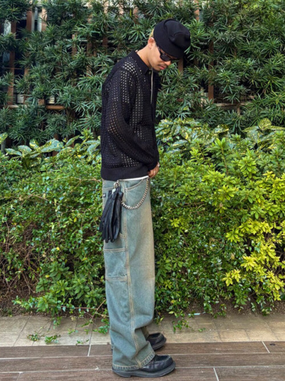 ブルー系のデニムパンツ、ブラック系のポロシャツ、ブラック系のニットキャップ/ビーニーを着用したメンズの春コーディネートの2枚目の写真