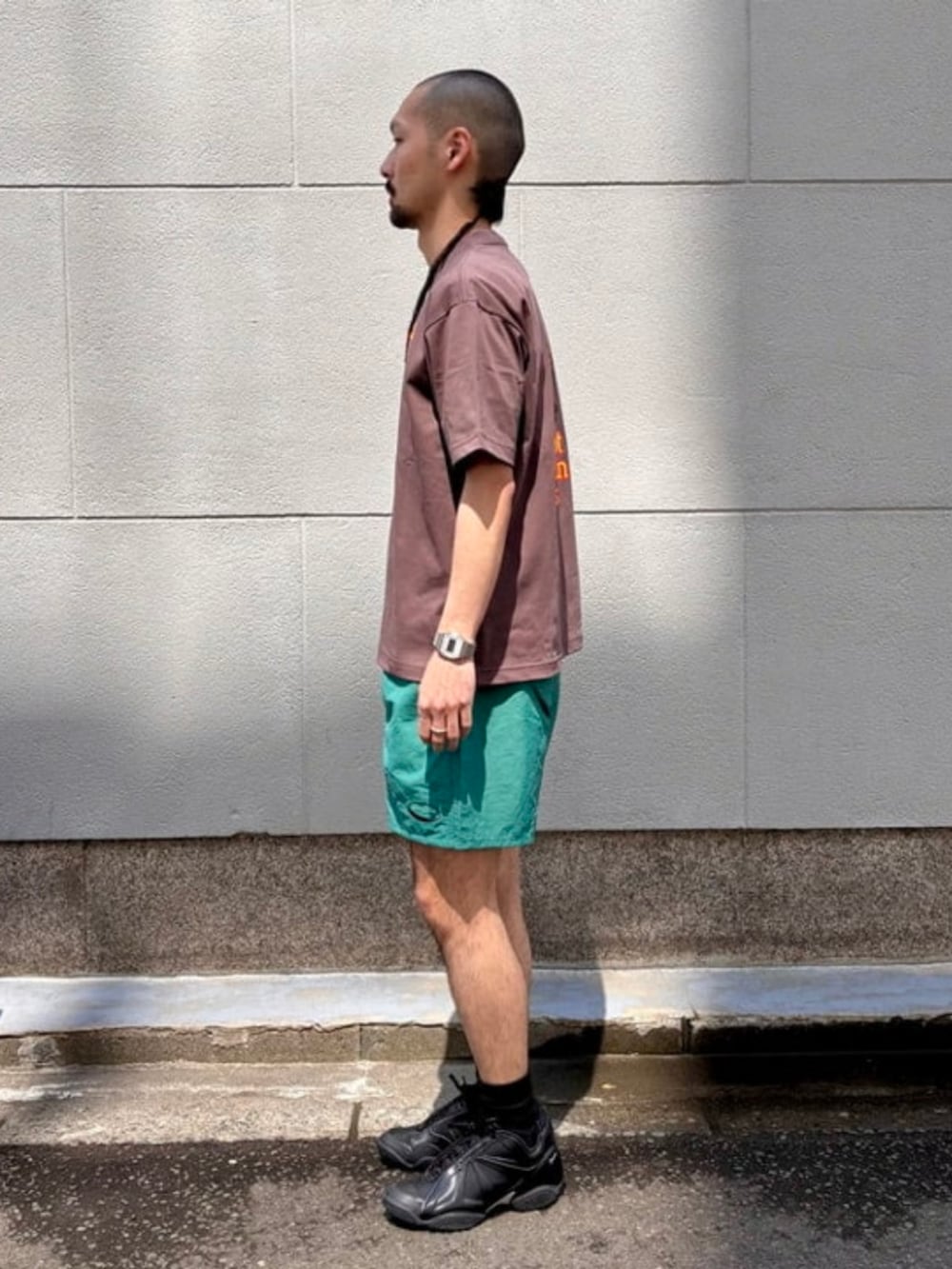 ブラウン系のTシャツ/カットソーを着用したメンズの春コーディネートの2枚目の写真