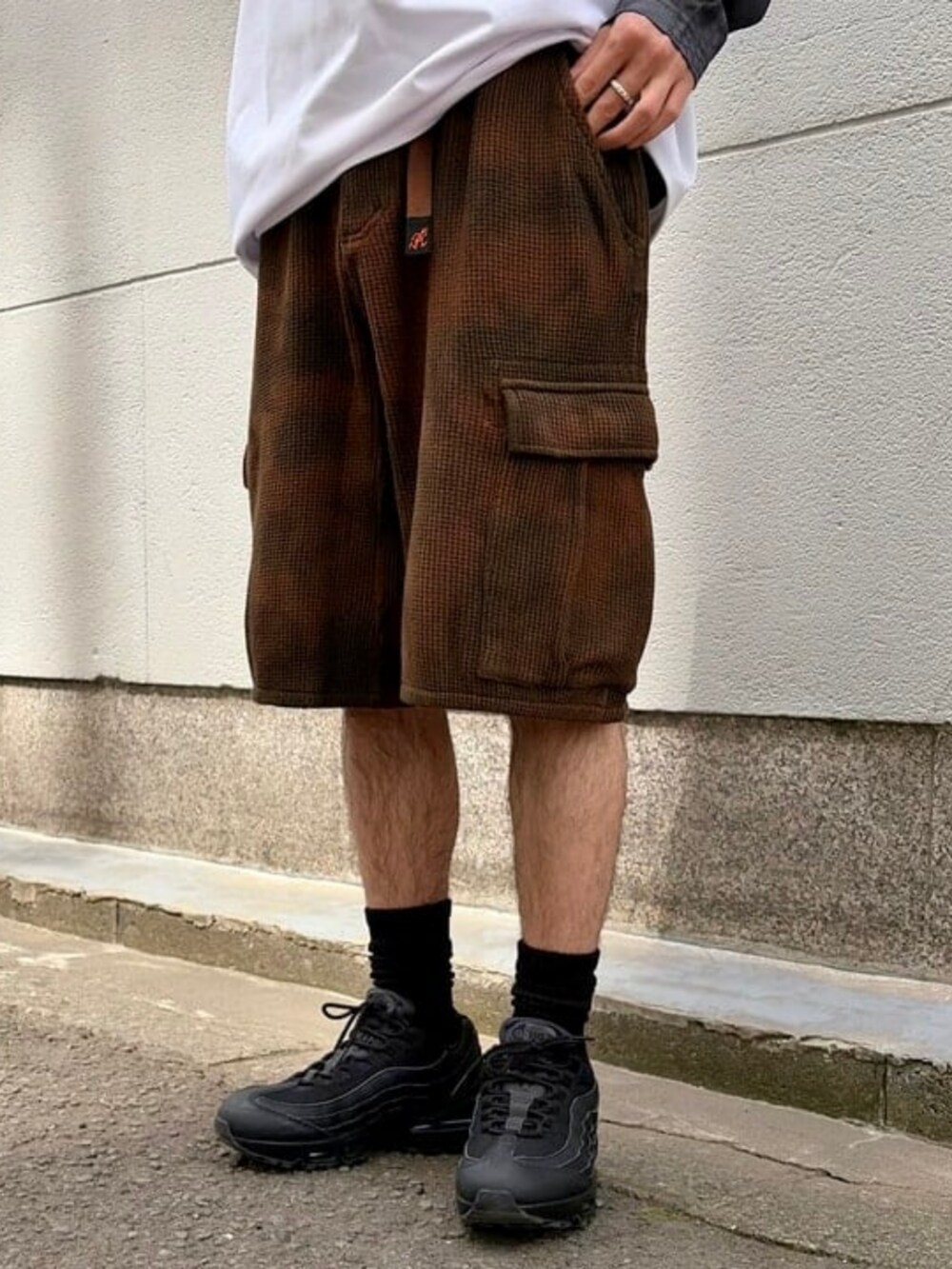 ホワイト系のTシャツ/カットソー、ブラウン系のカーゴパンツを着用したメンズの春コーディネートの2枚目の写真