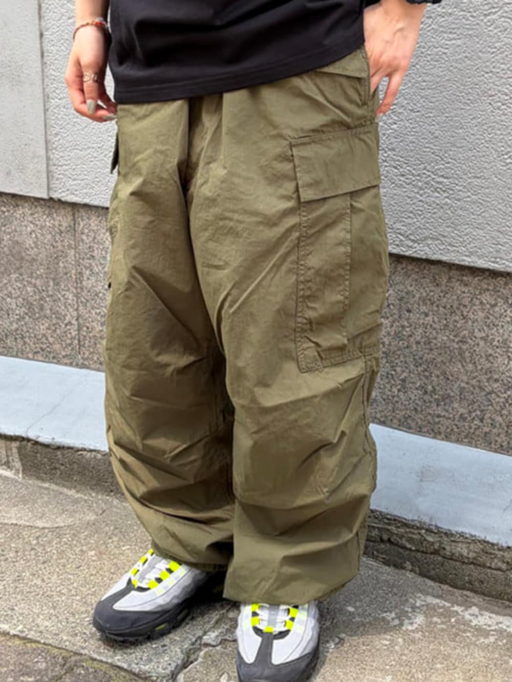 グリーン系のカーゴパンツ、ブラック系のTシャツ/カットソーを着用したメンズの夏コーディネートの4枚目の写真
