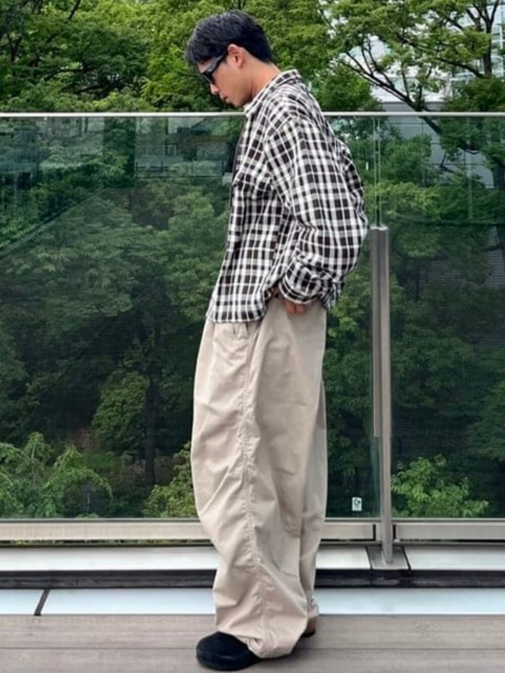 ベージュ系のチノパンツ、ブラック系のサンダルを着用したメンズの夏コーディネートの2枚目の写真