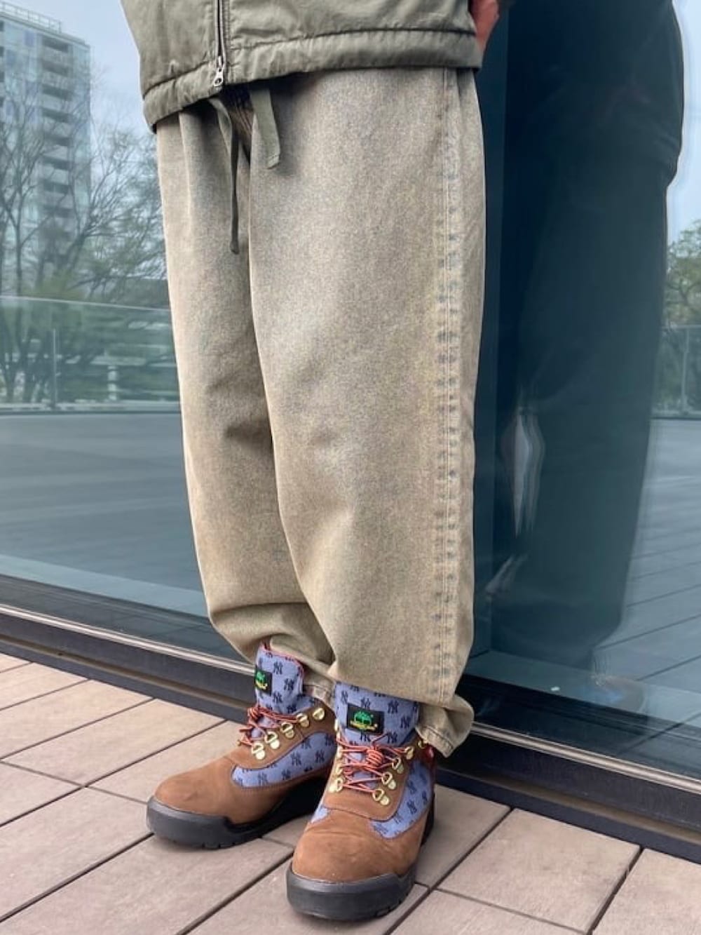 グリーン系のミリタリージャケット、ブルー系のデニムパンツを着用したメンズの春コーディネートの5枚目の写真