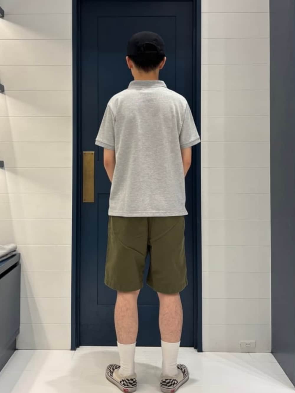 グレー系のポロシャツ、グリーン系のチノパンツ、ブラック系のハットを着用したメンズの夏コーディネートの2枚目の写真