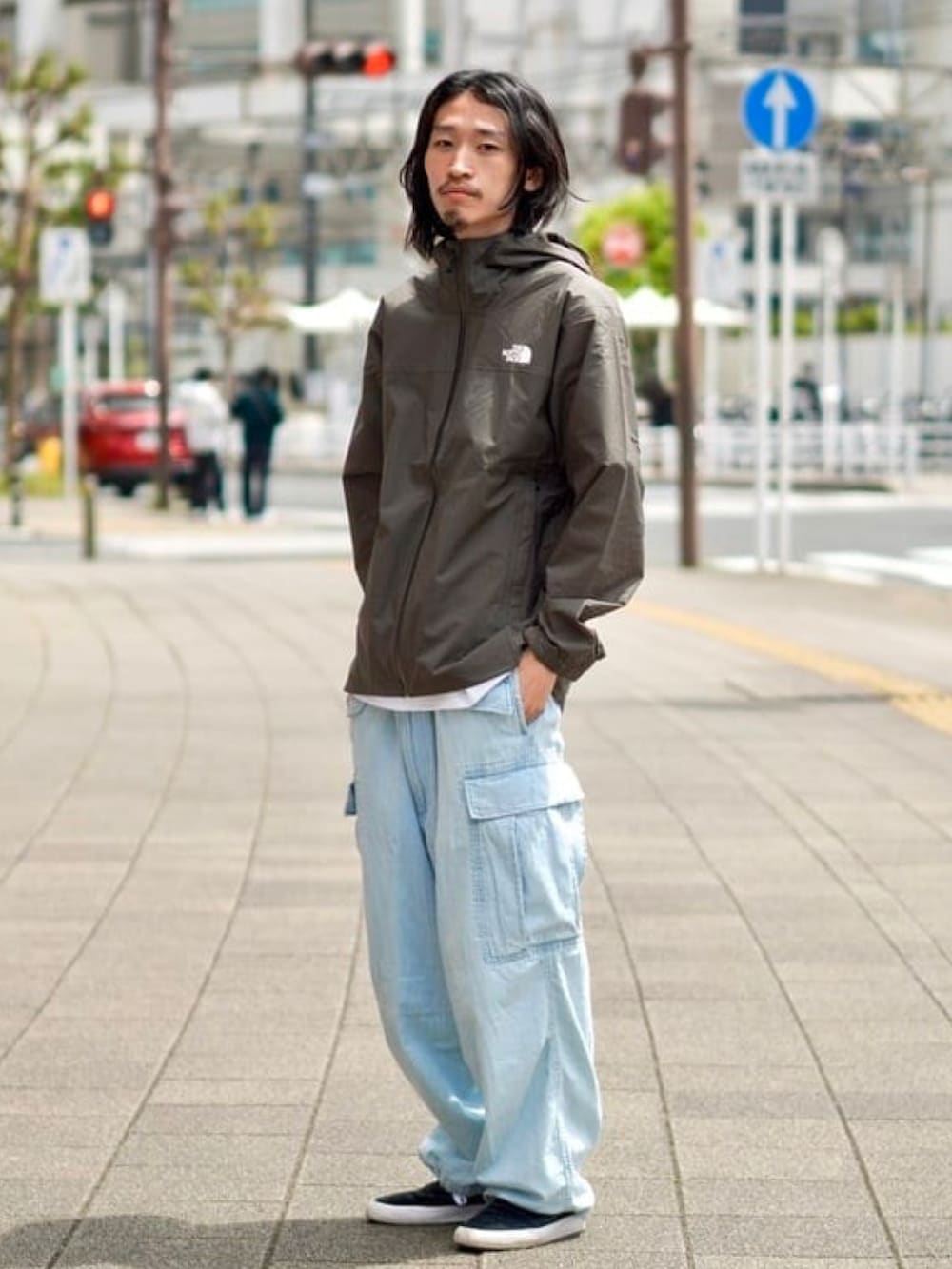 グリーン系のブルゾン、ホワイト系のTシャツ/カットソー、ブルー系のカーゴパンツを着用したメンズの春コーディネートの2枚目の写真