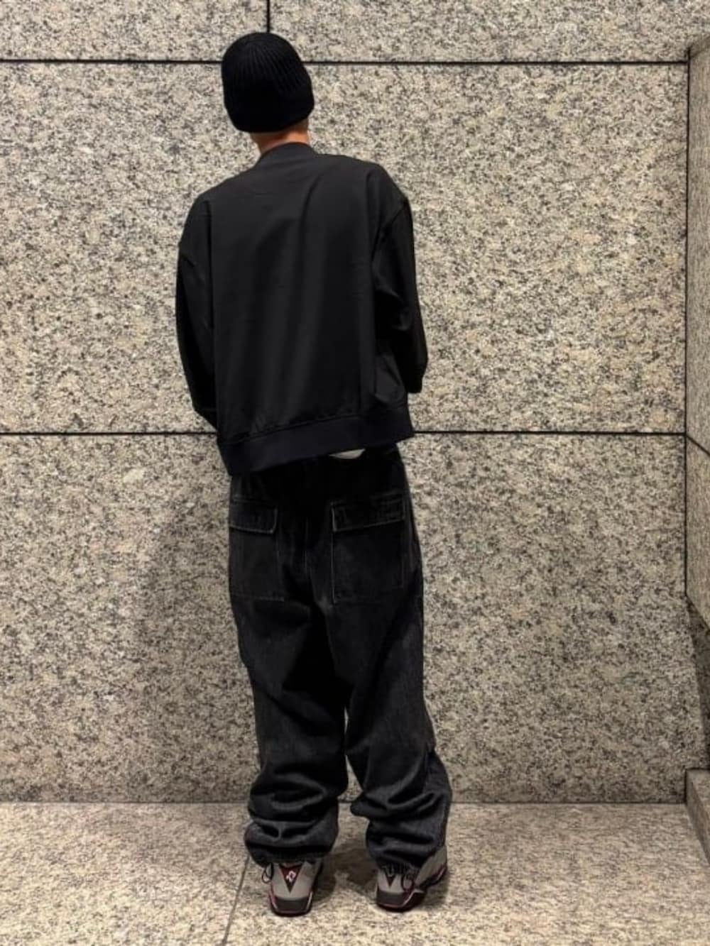 ブラック系のデニムパンツ、ブラック系のブルゾン、ブラック系のニットキャップ/ビーニーを着用したメンズの秋コーディネートの2枚目の写真