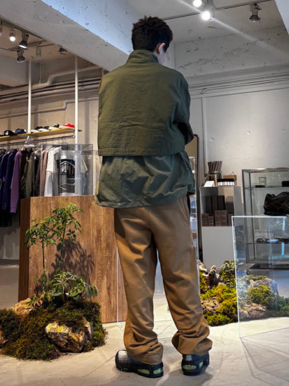 グリーン系のミリタリージャケットを着用したメンズの春コーディネートの2枚目の写真