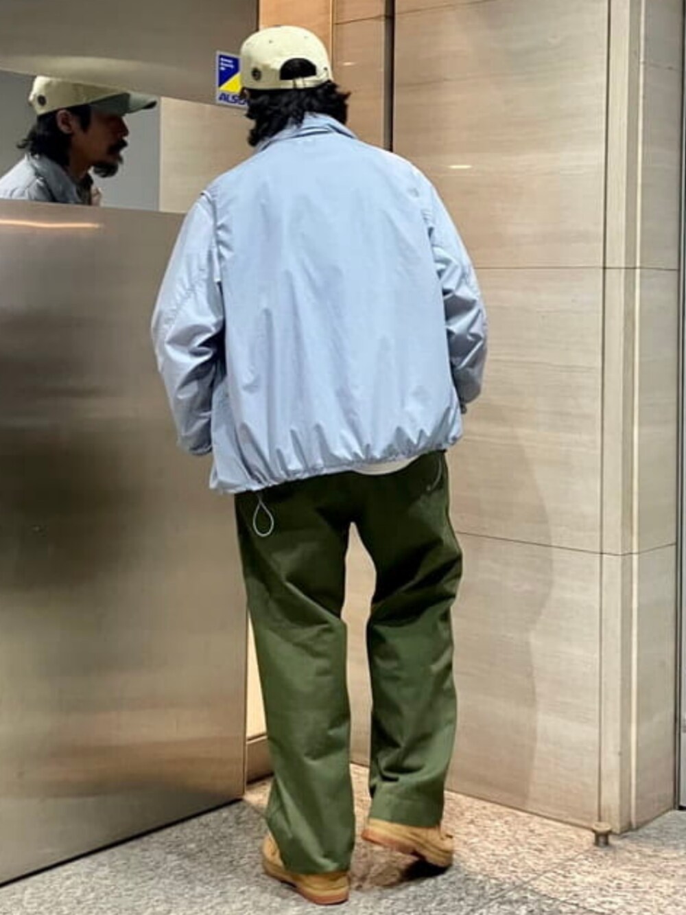 グレー系のブルゾン、グレー系のベスト、ブラウン系のキャップを着用したメンズの春コーディネートの3枚目の写真