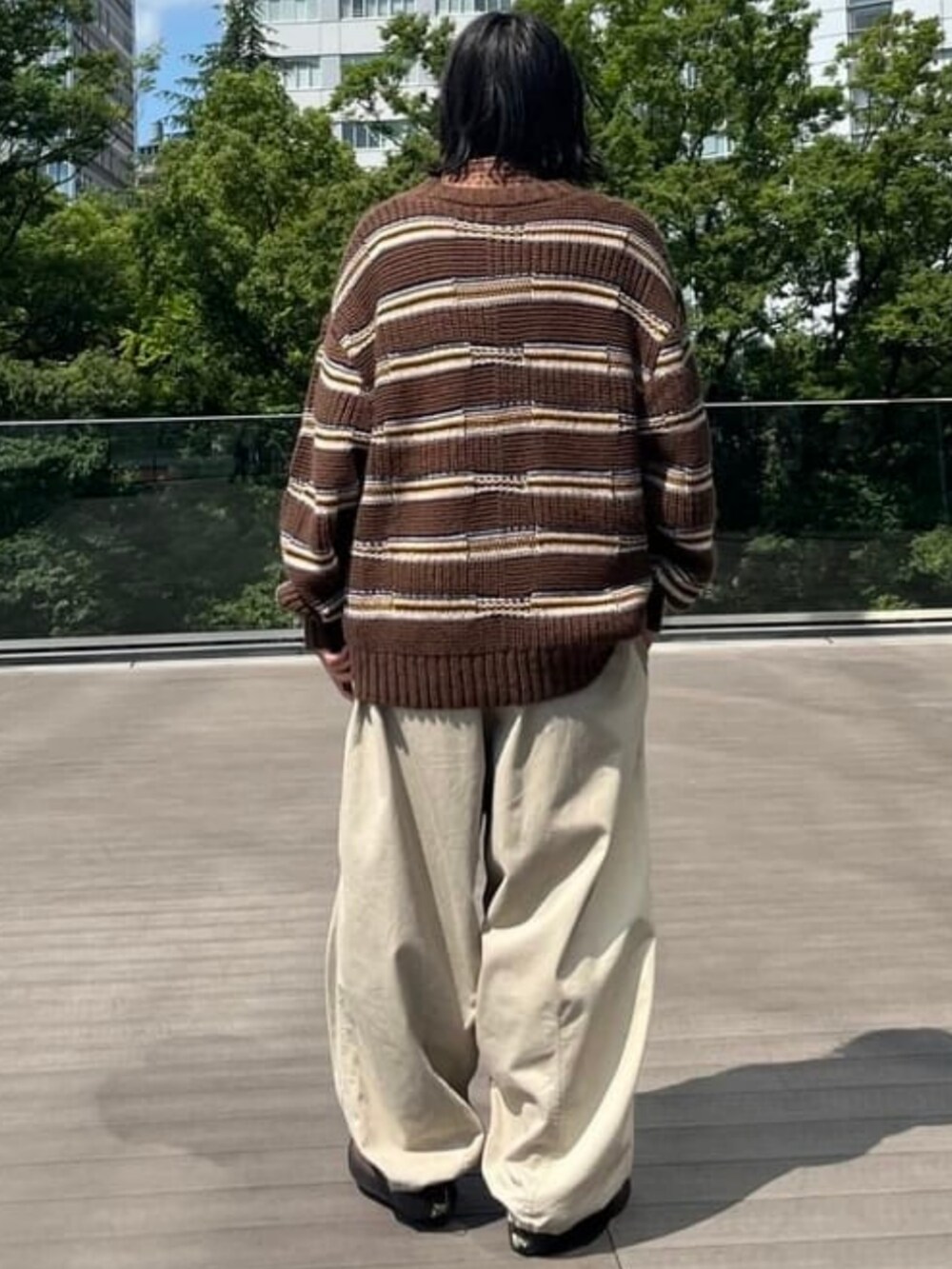 ベージュ系のチノパンツ、ブラウン系のニット/セーターを着用したメンズの夏コーディネートの2枚目の写真