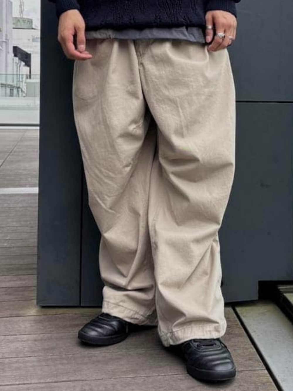 ブルー系のニット/セーター、ベージュ系のチノパンツを着用したメンズの夏コーディネートの5枚目の写真