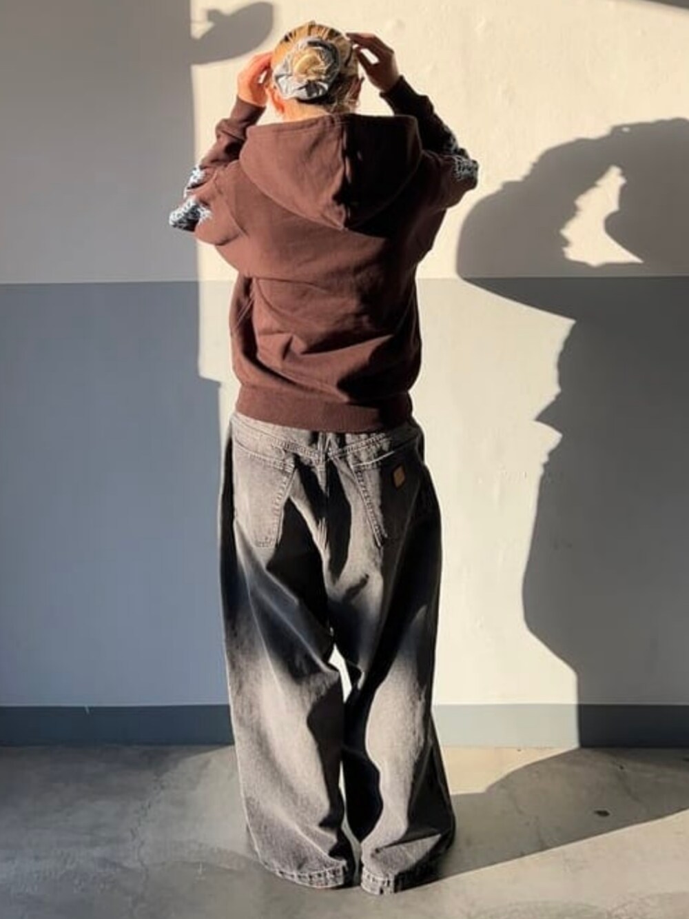 ブラック系のデニムパンツを着用したレディースの冬コーディネートの2枚目の写真