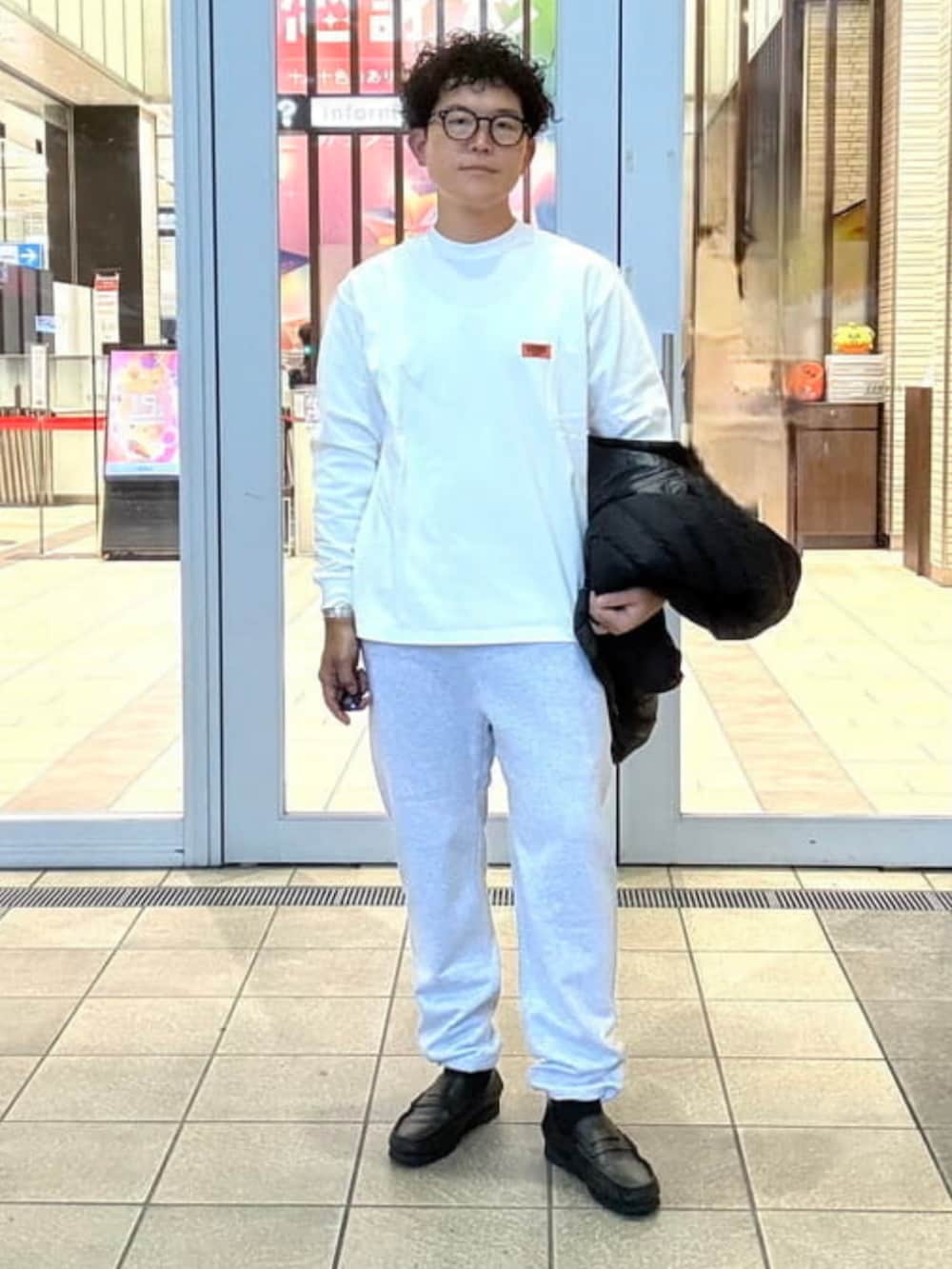 グレー系のスウェットパンツ、ブラック系のダウンジャケット/コート、ホワイト系のTシャツ/カットソーを着用したメンズの秋コーディネートの5枚目の写真