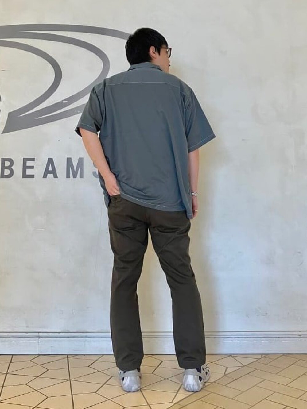 グレー系のシャツ/ブラウス、グレー系のチノパンツ、ホワイト系のサンダルを着用したメンズの夏コーディネートの2枚目の写真