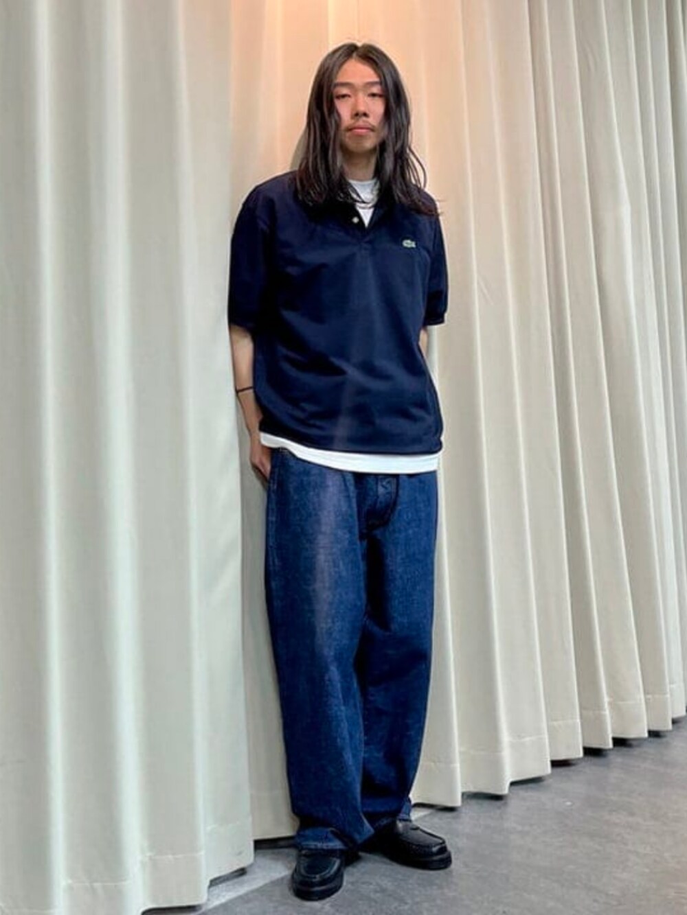 ブルー系のデニムパンツ、ブルー系のポロシャツ、ホワイト系のTシャツ/カットソーを着用したメンズの春コーディネートの2枚目の写真