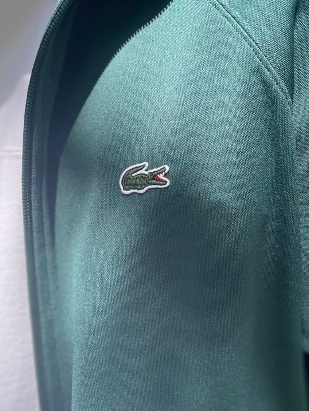 グリーン系のジャージ、ホワイト系のTシャツ/カットソー、ブルー系のデニムパンツを着用したメンズの春コーディネートの4枚目の写真