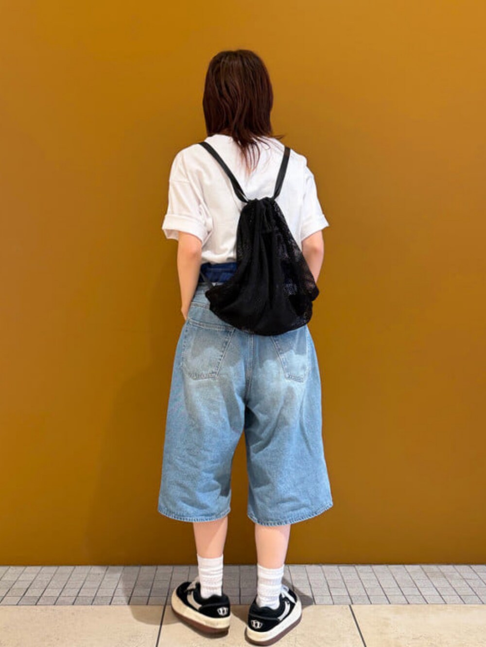ホワイト系のTシャツ/カットソー、ブルー系のその他パンツ、ブラック系のバックパック/リュックを着用したレディースの春コーディネートの2枚目の写真