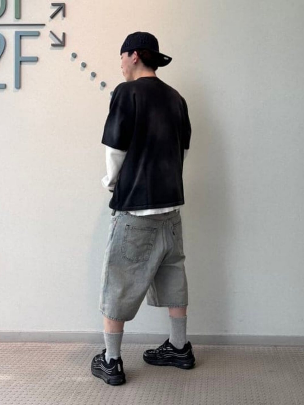 ブルー系のデニムパンツ、ブラック系のTシャツ/カットソー、ブルー系のキャップを着用したメンズの春コーディネートの3枚目の写真