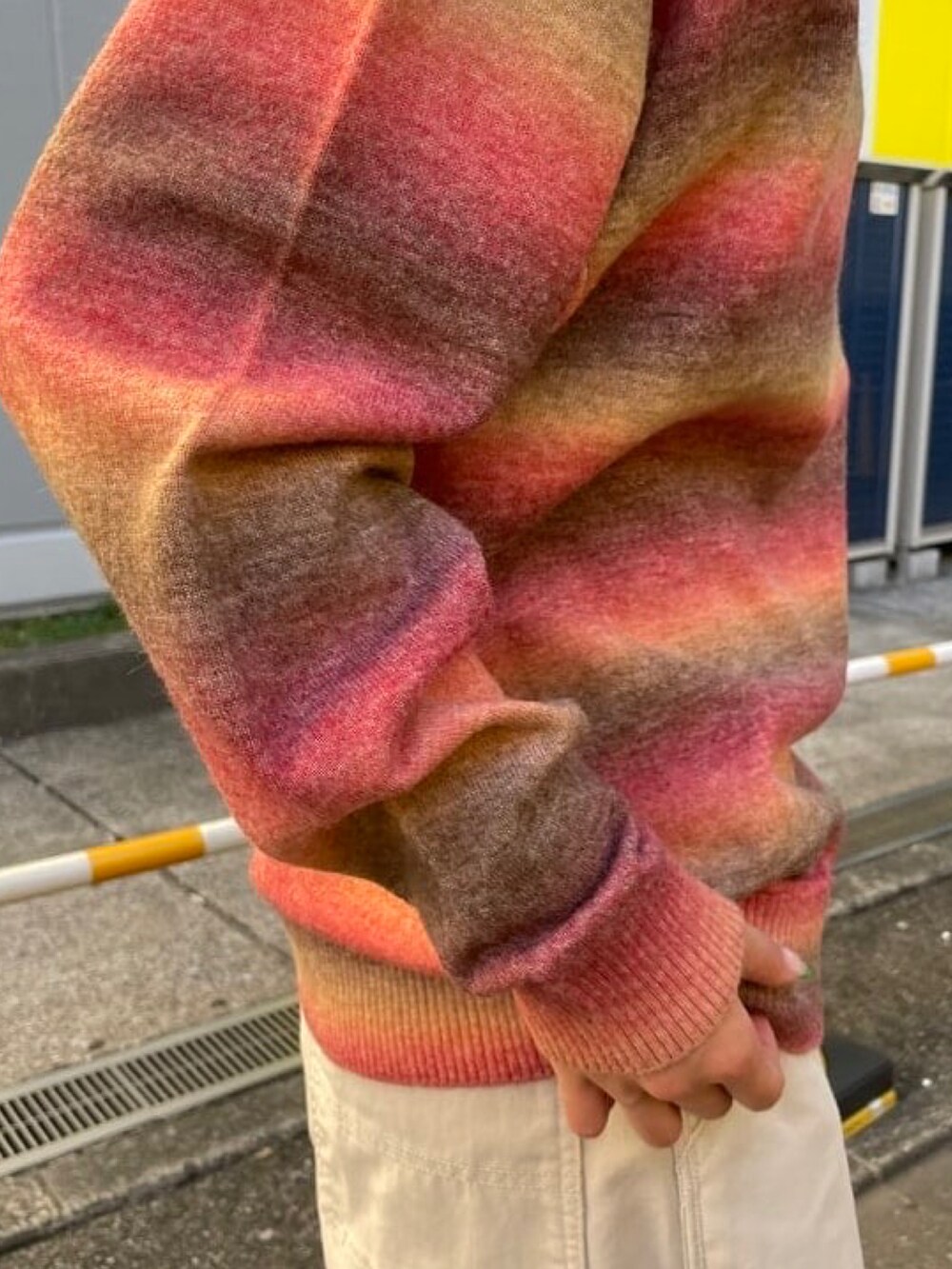 レッド系のニット/セーター、グレー系のベスト、グレー系のその他パンツを着用したレディースの秋コーディネートの5枚目の写真