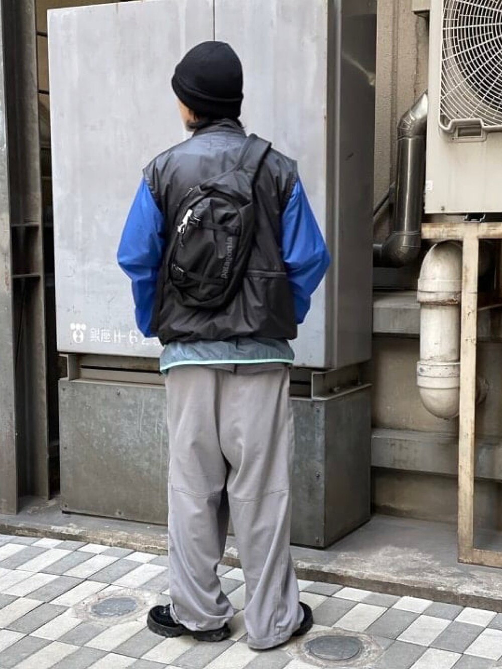 ブラック系のベスト、グレー系のカーゴパンツ、ブラック系のニットキャップ/ビーニーを着用したメンズの春コーディネートの3枚目の写真