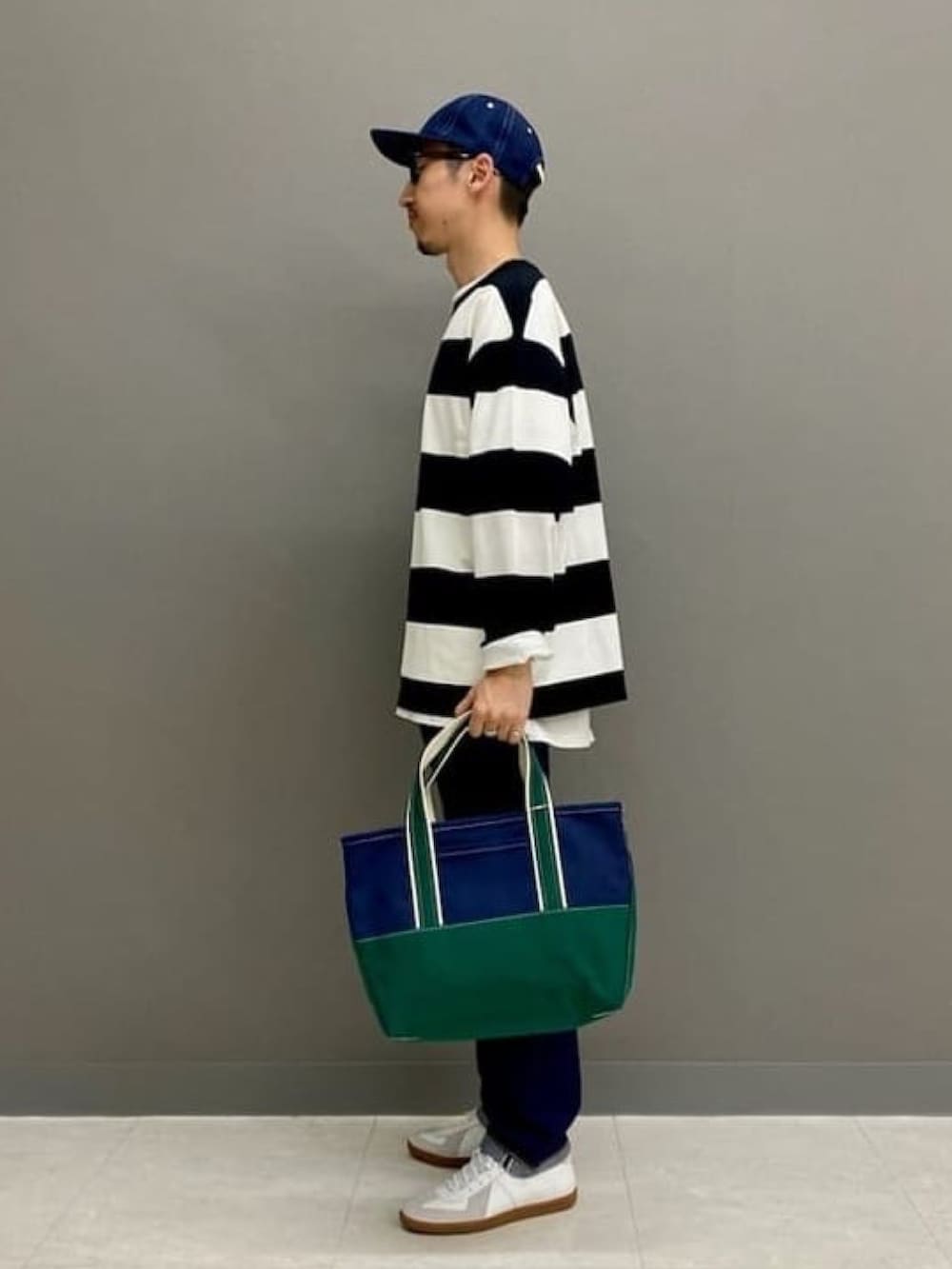 ブラック系のTシャツ/カットソー、ブルー系のデニムパンツ、ホワイト系のスニーカーを着用したメンズの春コーディネートの2枚目の写真