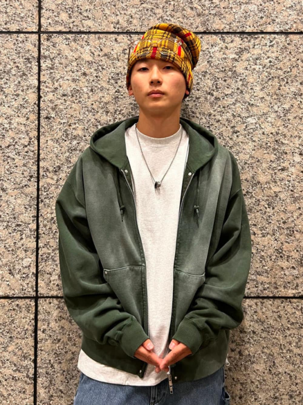 グリーン系のパーカー、ホワイト系のTシャツ/カットソー、ブルー系のデニムパンツを着用したメンズの春コーディネートの6枚目の写真