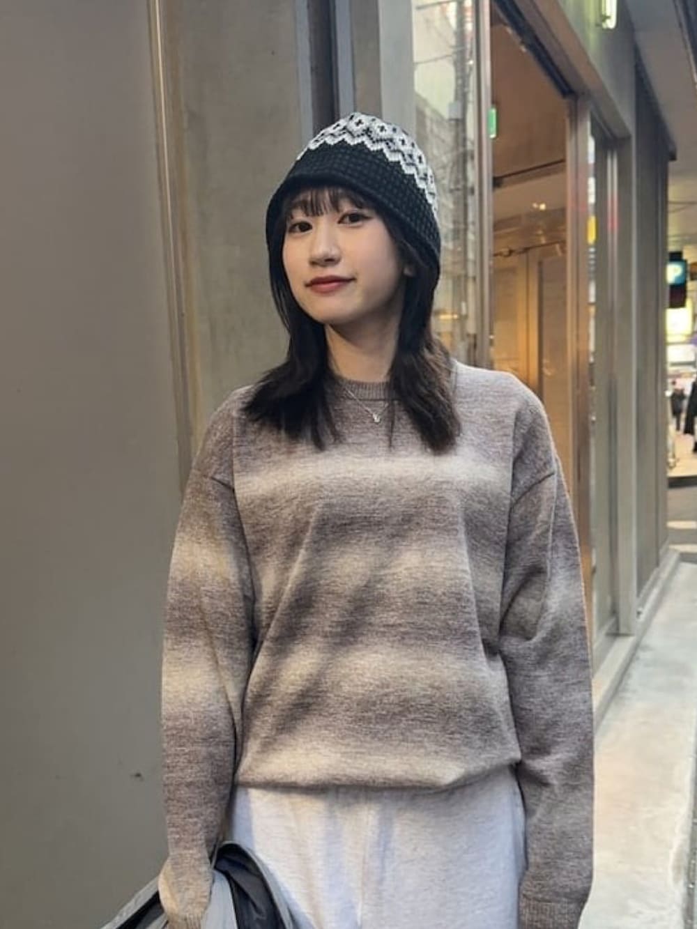 グレー系のスウェットパンツ、ブラウン系のニット/セーター、グレー系のベストを着用したレディースの秋コーディネートの2枚目の写真