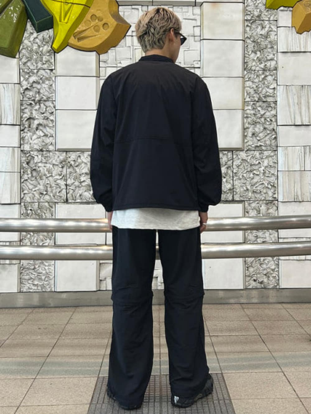 ブラック系のブルゾン、ブラック系のその他パンツ、シルバー系のTシャツ/カットソーを着用したメンズの春コーディネートの3枚目の写真