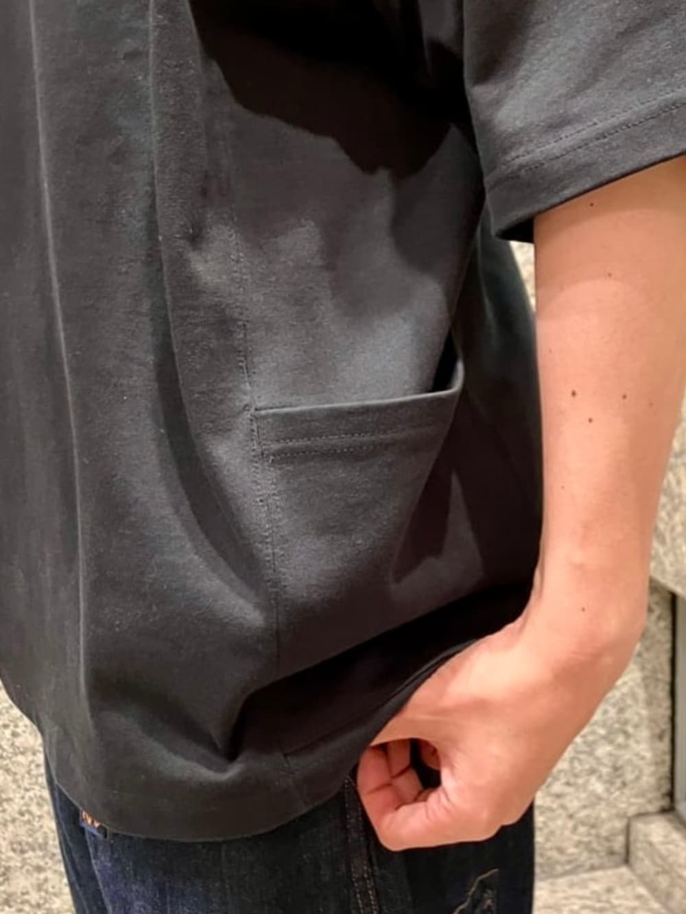 ブルー系のデニムパンツ、ブラック系のボディバッグ/ウエストポーチ、ブラック系のTシャツ/カットソーを着用したメンズの夏コーディネートの3枚目の写真