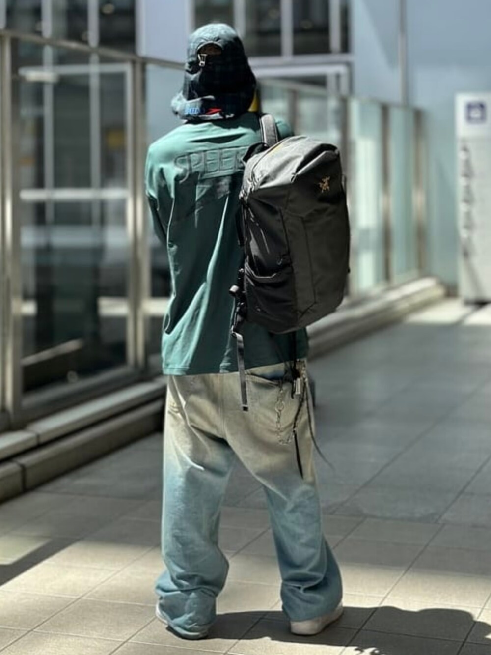 ブラック系のバックパック/リュック、グリーン系のTシャツ/カットソー、その他のハットを着用したメンズの夏コーディネートの2枚目の写真