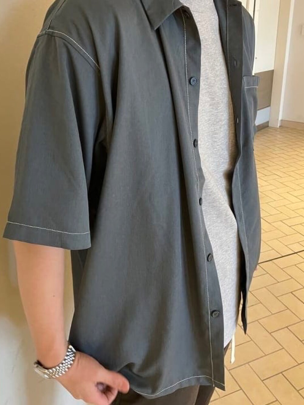 グレー系のシャツ/ブラウス、グレー系のチノパンツ、ホワイト系のサンダルを着用したメンズの夏コーディネートの4枚目の写真