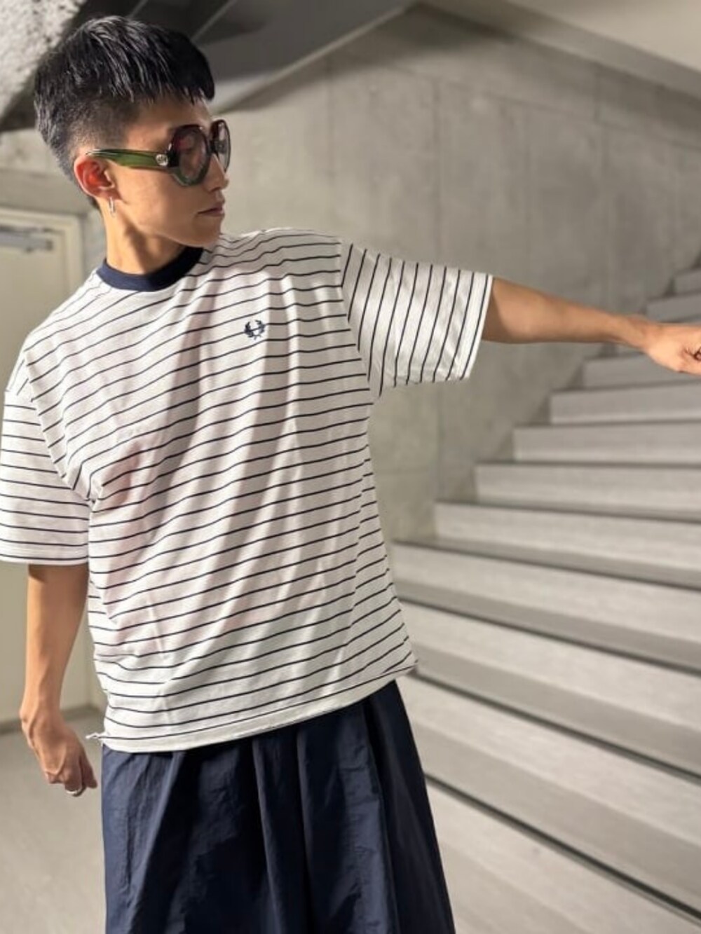 ホワイト系のTシャツ/カットソー、ブラック系のベスト、ブルー系のデニムパンツを着用したメンズの春コーディネートの4枚目の写真