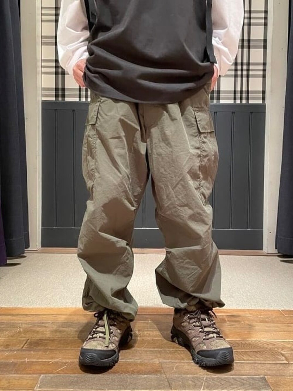 ブラック系のTシャツ/カットソー、グリーン系のカーゴパンツ、グリーン系のスニーカーを着用したメンズの春コーディネートの4枚目の写真