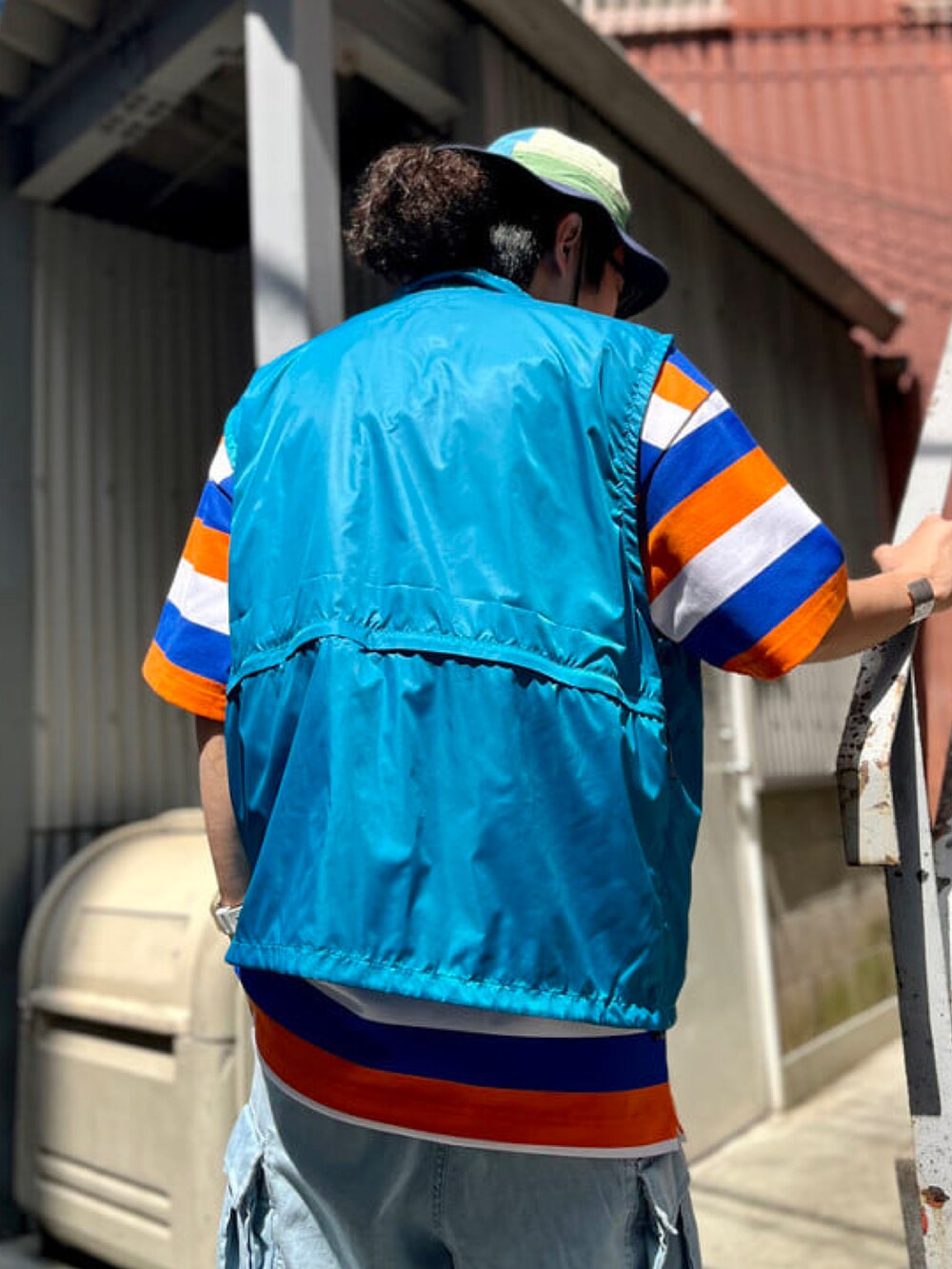 ホワイト系のTシャツ/カットソー、ブルー系のベスト、ブルー系のカーゴパンツを着用したメンズの春コーディネートの2枚目の写真