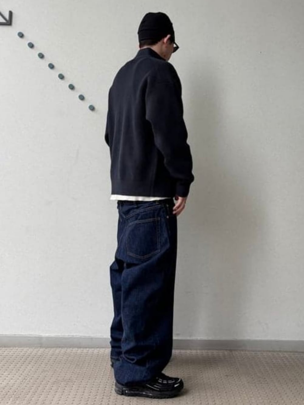 ブルー系のデニムパンツ、ブラック系のカーディガン/ボレロ、ベージュ系のTシャツ/カットソーを着用したメンズの秋コーディネートの3枚目の写真