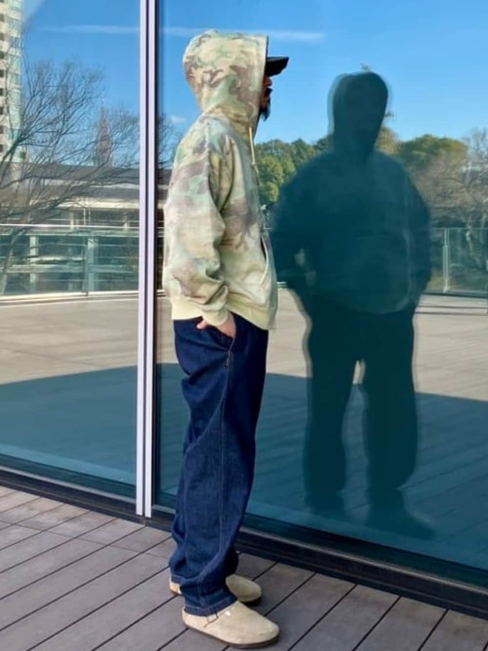 その他のスウェット、ブルー系のデニムパンツ、グリーン系のキャップを着用したメンズの春コーディネートの2枚目の写真