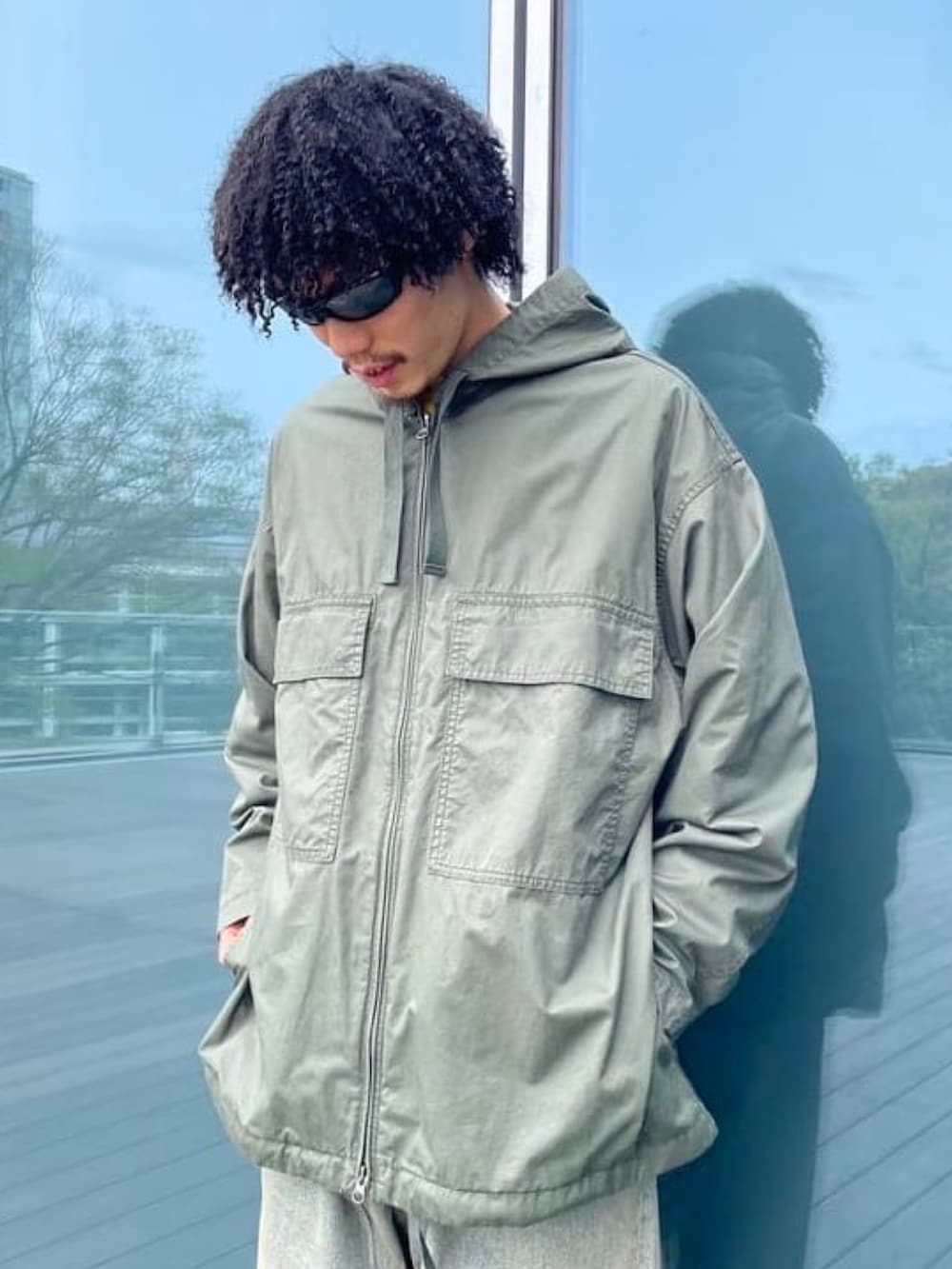 グリーン系のミリタリージャケット、ブルー系のデニムパンツを着用したメンズの春コーディネートの4枚目の写真