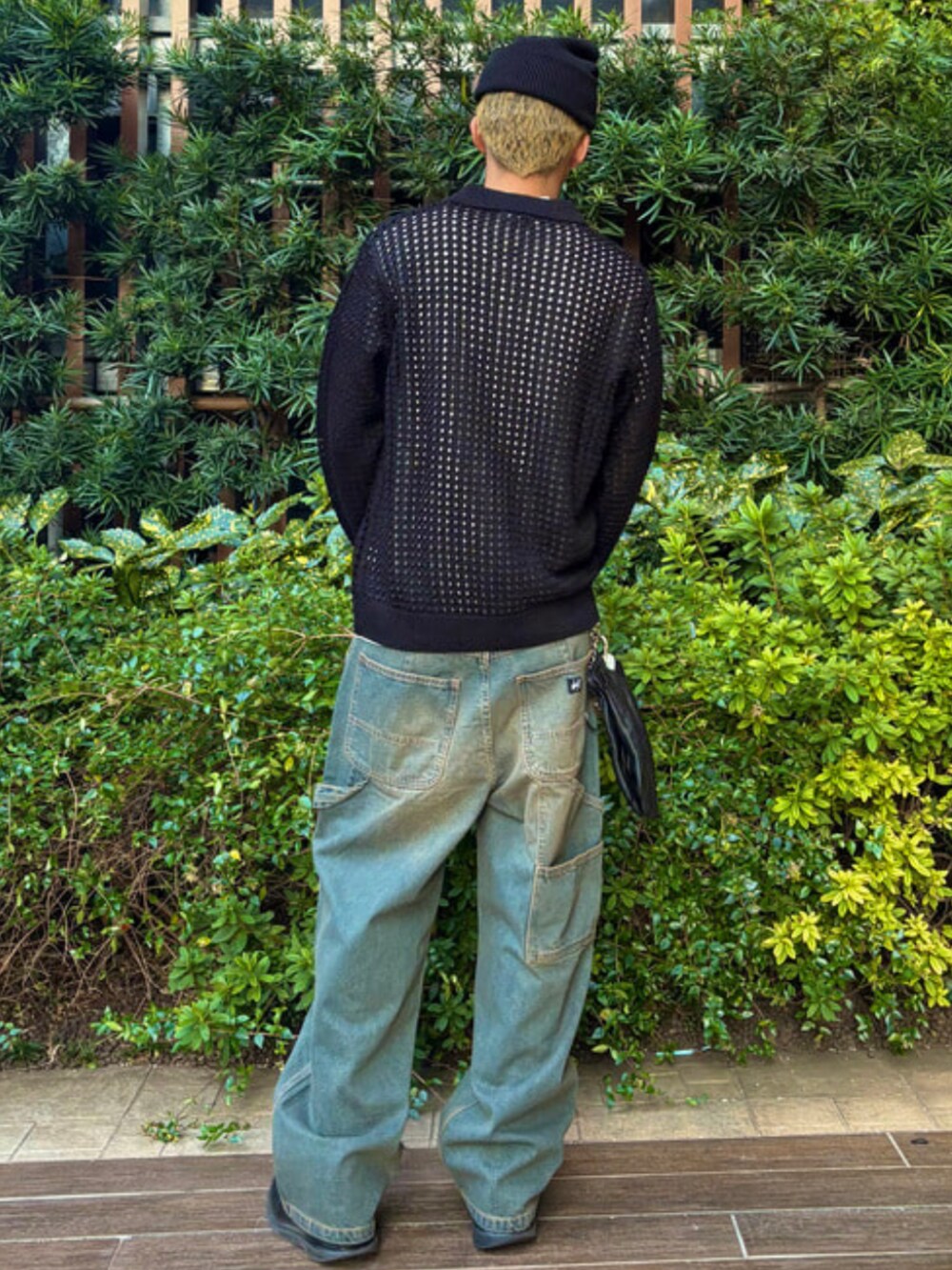 ブルー系のデニムパンツ、ブラック系のポロシャツ、ブラック系のニットキャップ/ビーニーを着用したメンズの春コーディネートの3枚目の写真