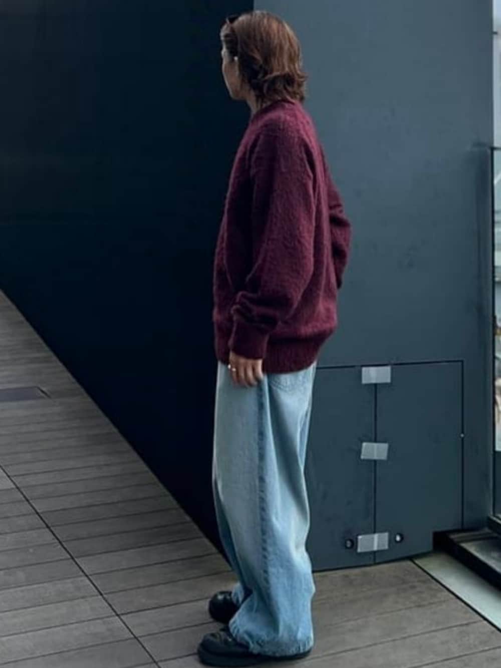 レッド系のニット/セーター、ブルー系のデニムパンツを着用したメンズの夏コーディネートの2枚目の写真