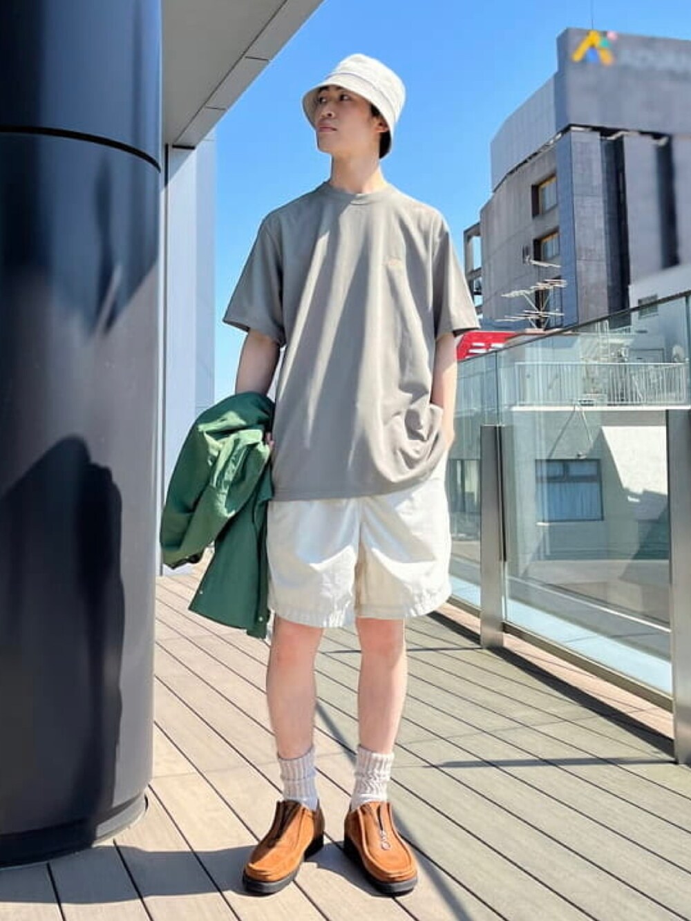 グリーン系のTシャツ/カットソー、ベージュ系のハットを着用したメンズの春コーディネートの2枚目の写真