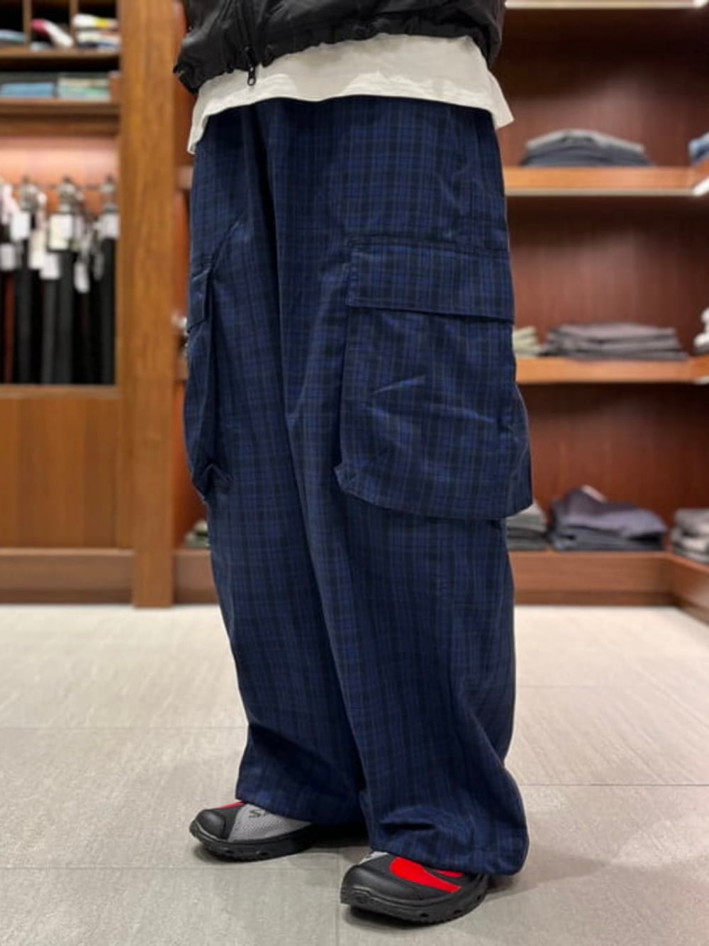 ブルー系のカーゴパンツ、ブラック系のサンダル、ブラック系のベストを着用したメンズの夏コーディネートの3枚目の写真