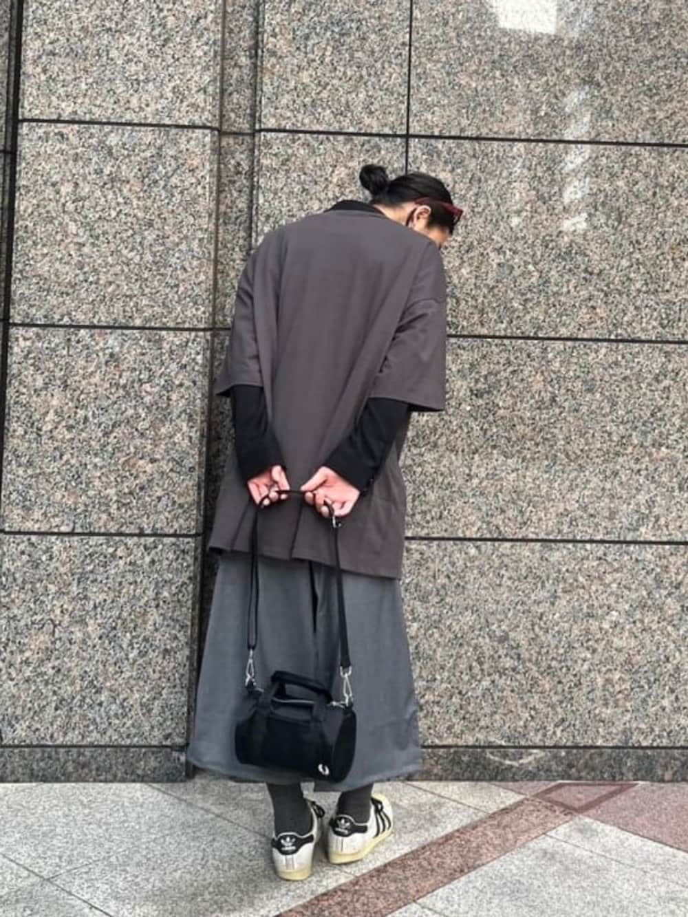 ブラック系のショルダーバッグ、ブラック系のTシャツ/カットソー、グレー系のスラックスを着用したメンズの夏コーディネートの2枚目の写真