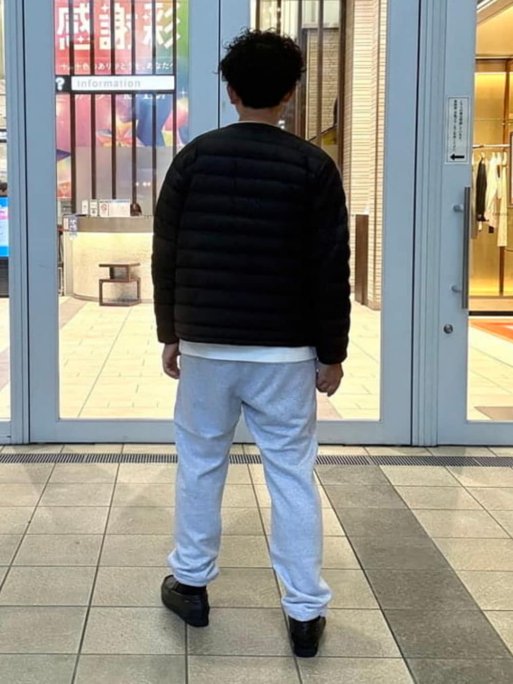 グレー系のスウェットパンツ、ブラック系のダウンジャケット/コート、ホワイト系のTシャツ/カットソーを着用したメンズの秋コーディネートの4枚目の写真