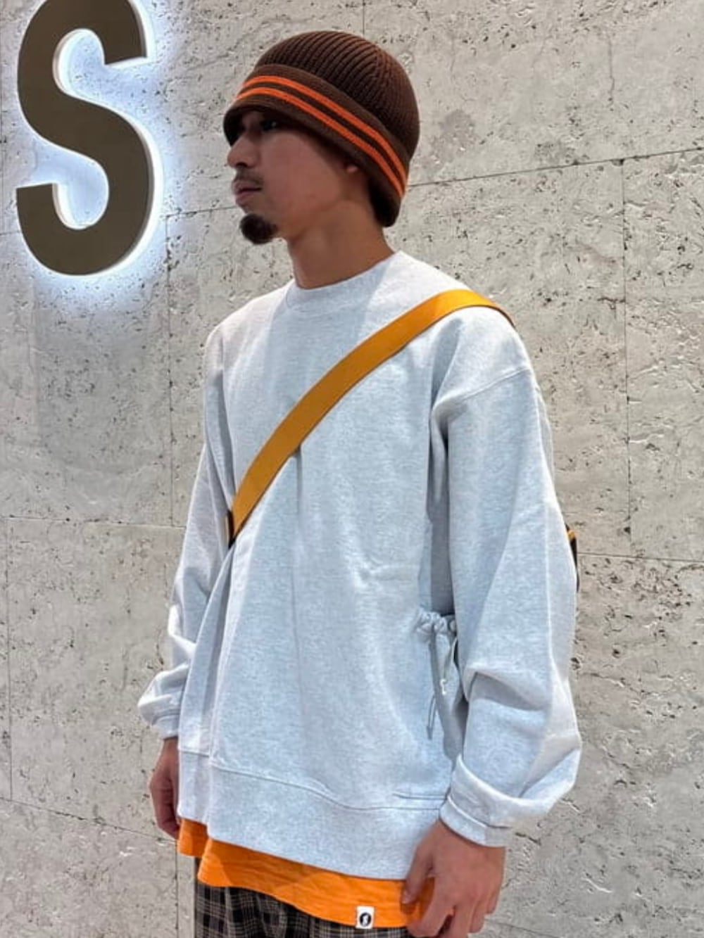 グレー系のスウェット、ブラウン系のその他パンツ、ブラウン系のハットを着用したメンズの秋コーディネートの2枚目の写真