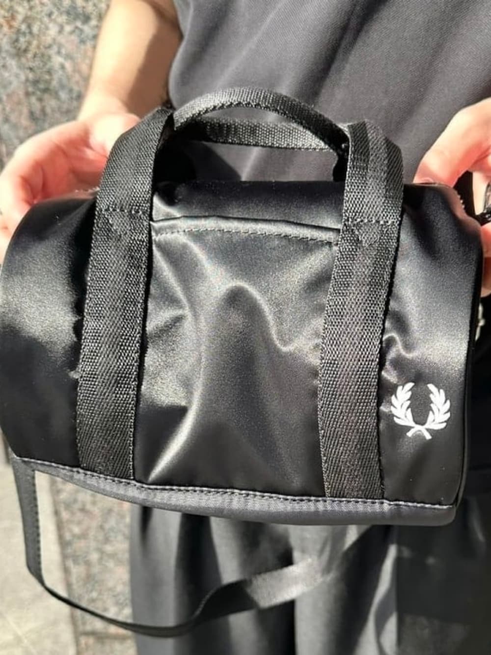 ブラック系のポロシャツ、ブラック系のスラックス、ブラック系のショルダーバッグを着用したメンズの夏コーディネートの3枚目の写真