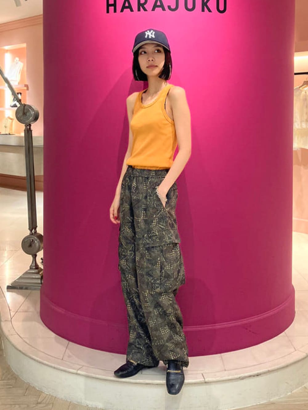 グリーン系のカーゴパンツ、ブルー系のキャップを着用したメンズの夏コーディネートの2枚目の写真