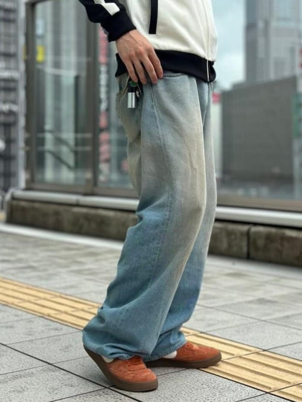 ホワイト系のジャージ、ブルー系のデニムパンツ、ブラック系のサングラスを着用したメンズの夏コーディネートの4枚目の写真