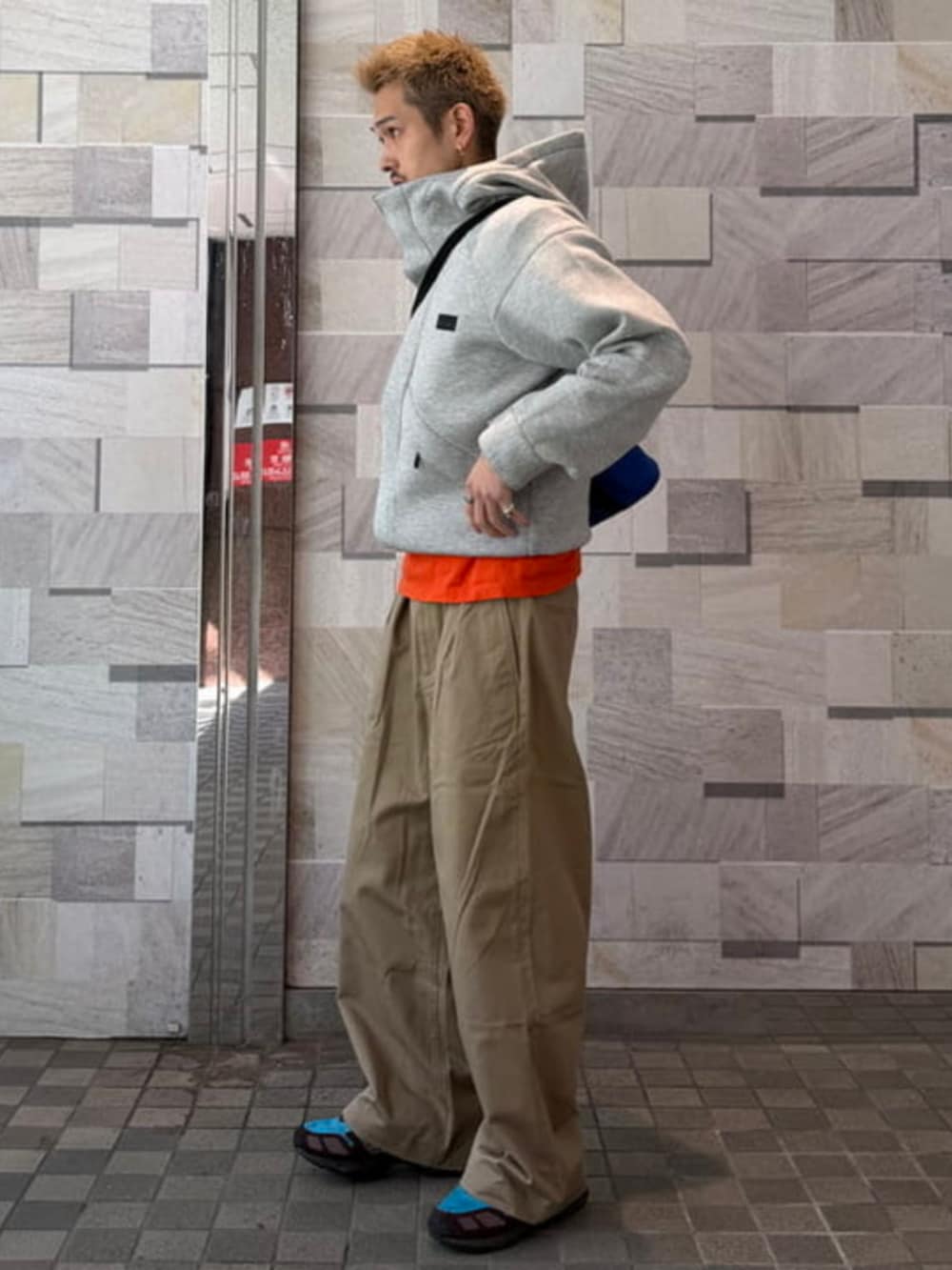 グレー系のパーカー、ベージュ系のその他パンツを着用したメンズの冬コーディネートの2枚目の写真